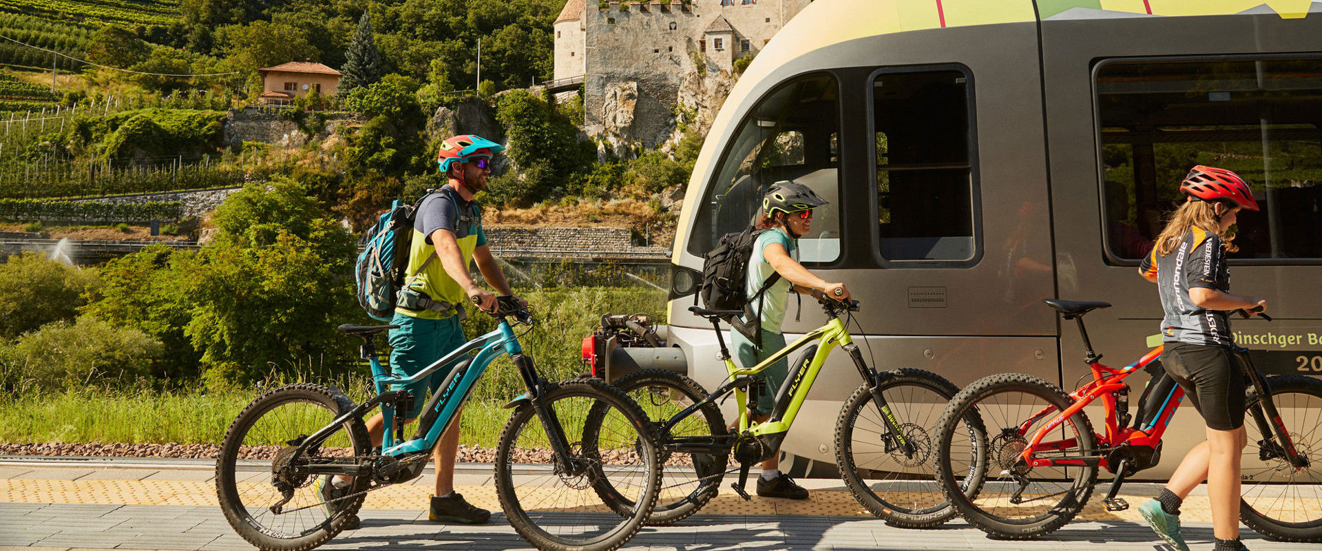 Travelling by bike and train Three cyclists are standing on the platform waiting for the train.