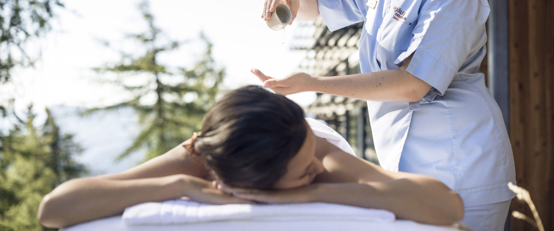 Wellness treatment Woman on a couch being massaged with oil.