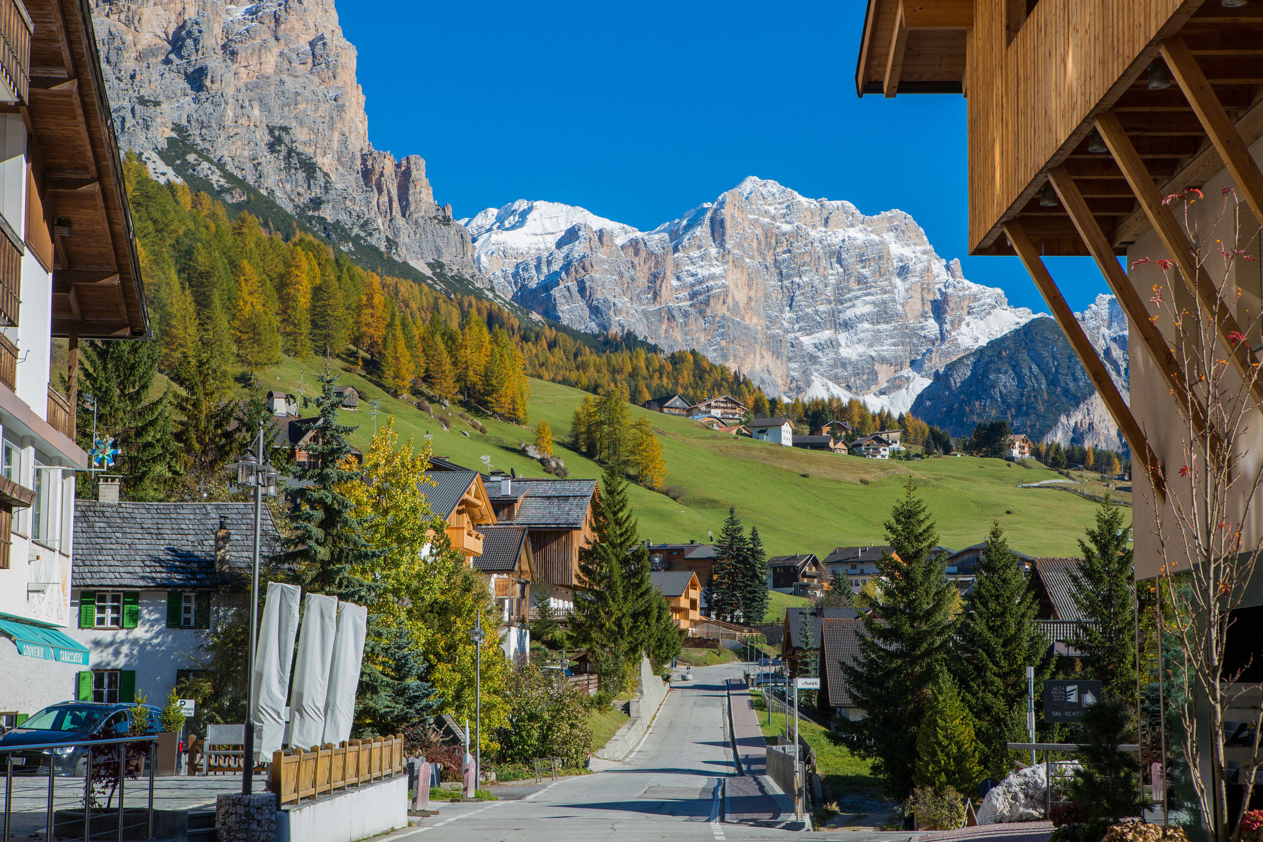 Street and houses in St. Kassian, cloudless sky and autumn colours