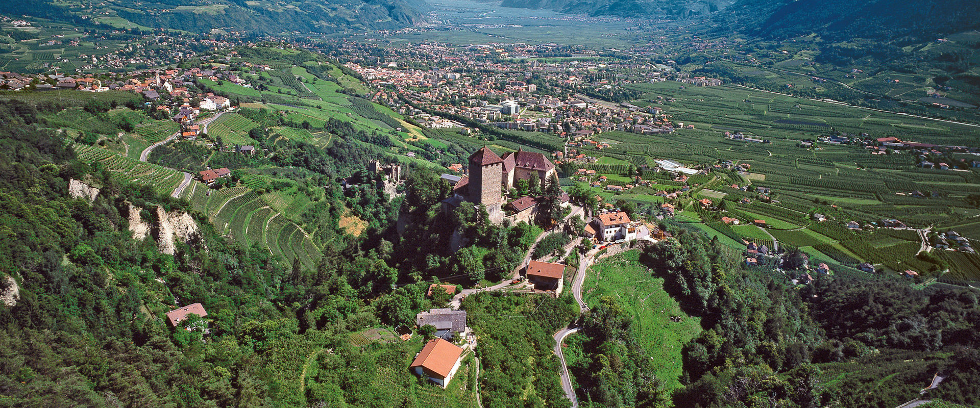 Castle Tyrol Aerial view of Castle Tyrol, nestled in green slopes.
