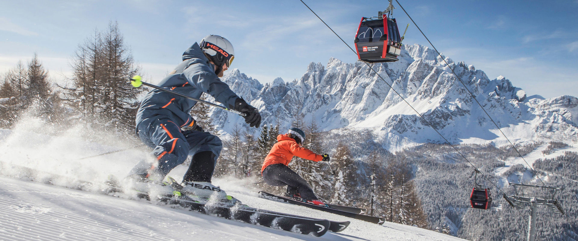 Skiing in Hochpustertal. Two skiers on freshly groomed slope below the cable car.