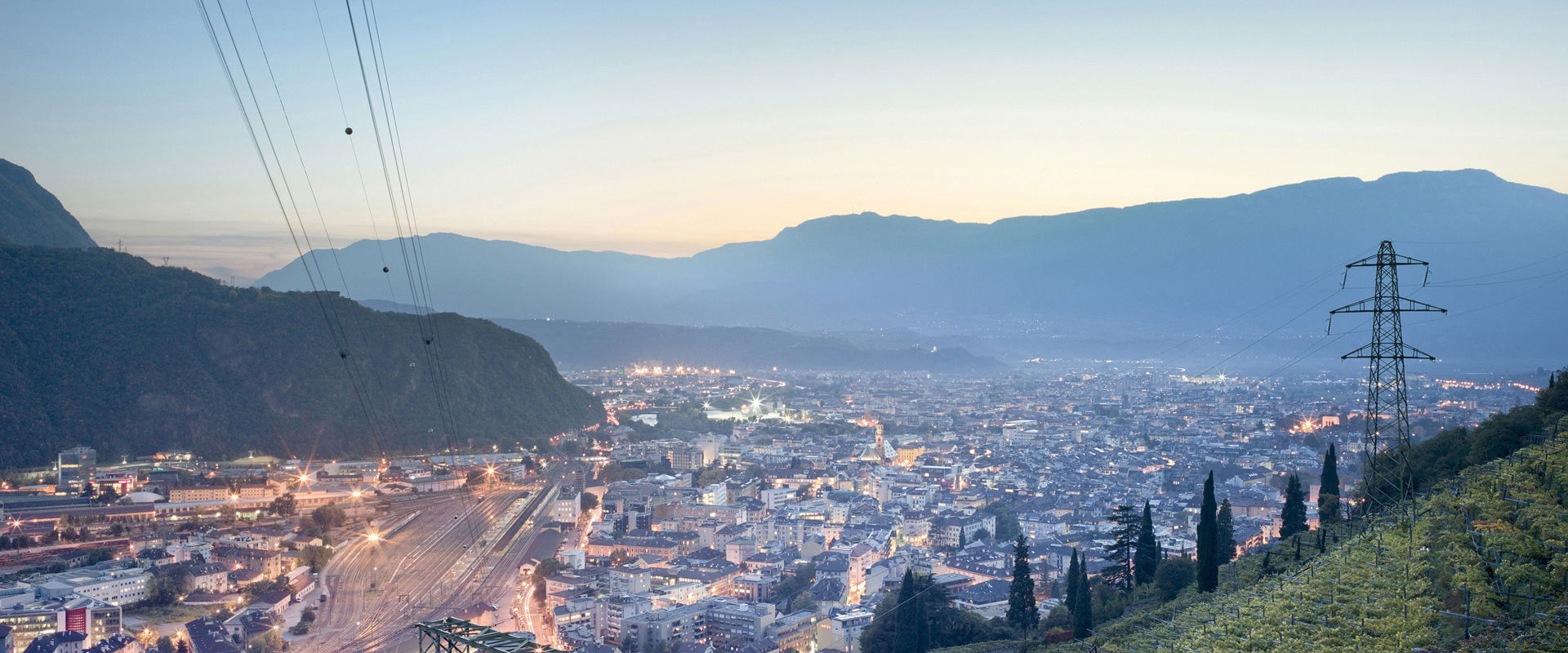 Summer evening in Bozen. Town illuminated in the early evening, lined with vineyards.