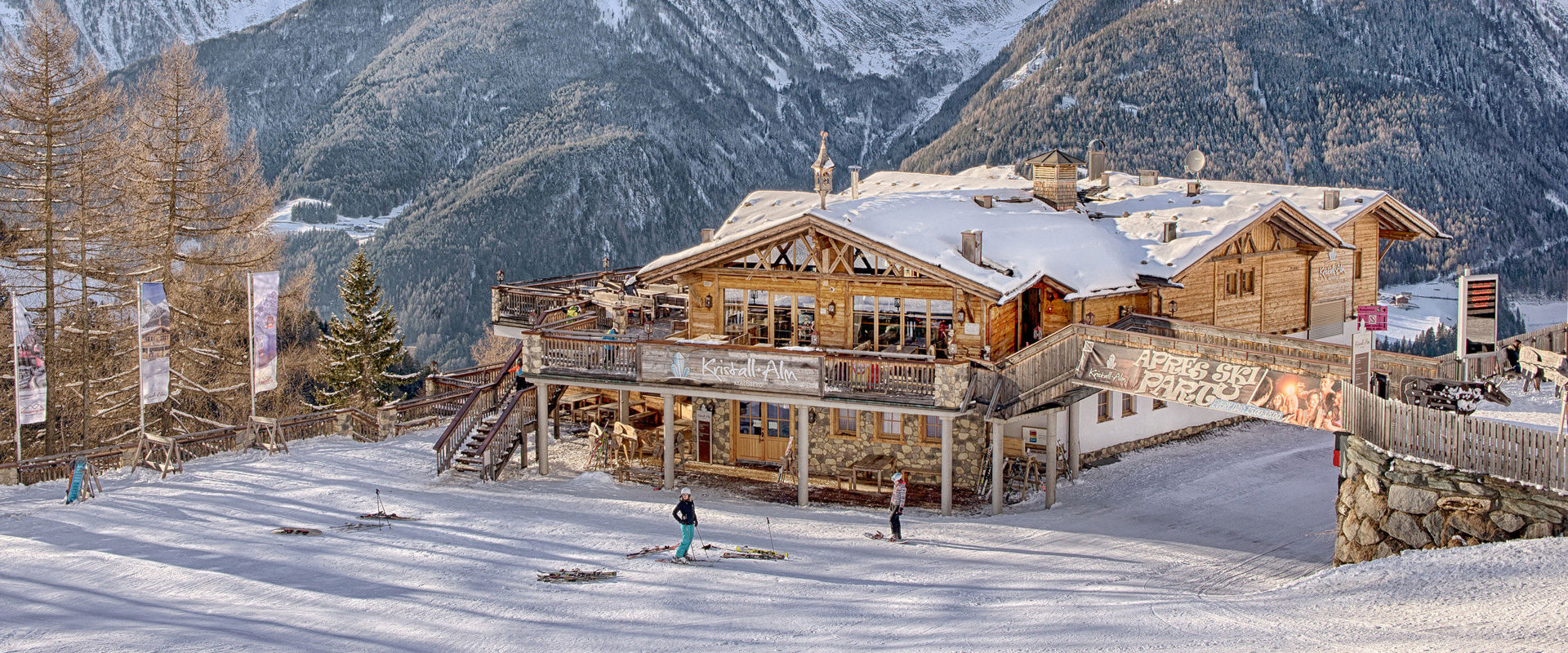 Kristallalm in the Klausberg ski area Large, wood-clad mountain hut on the ski slope, snow covered mountains behind it