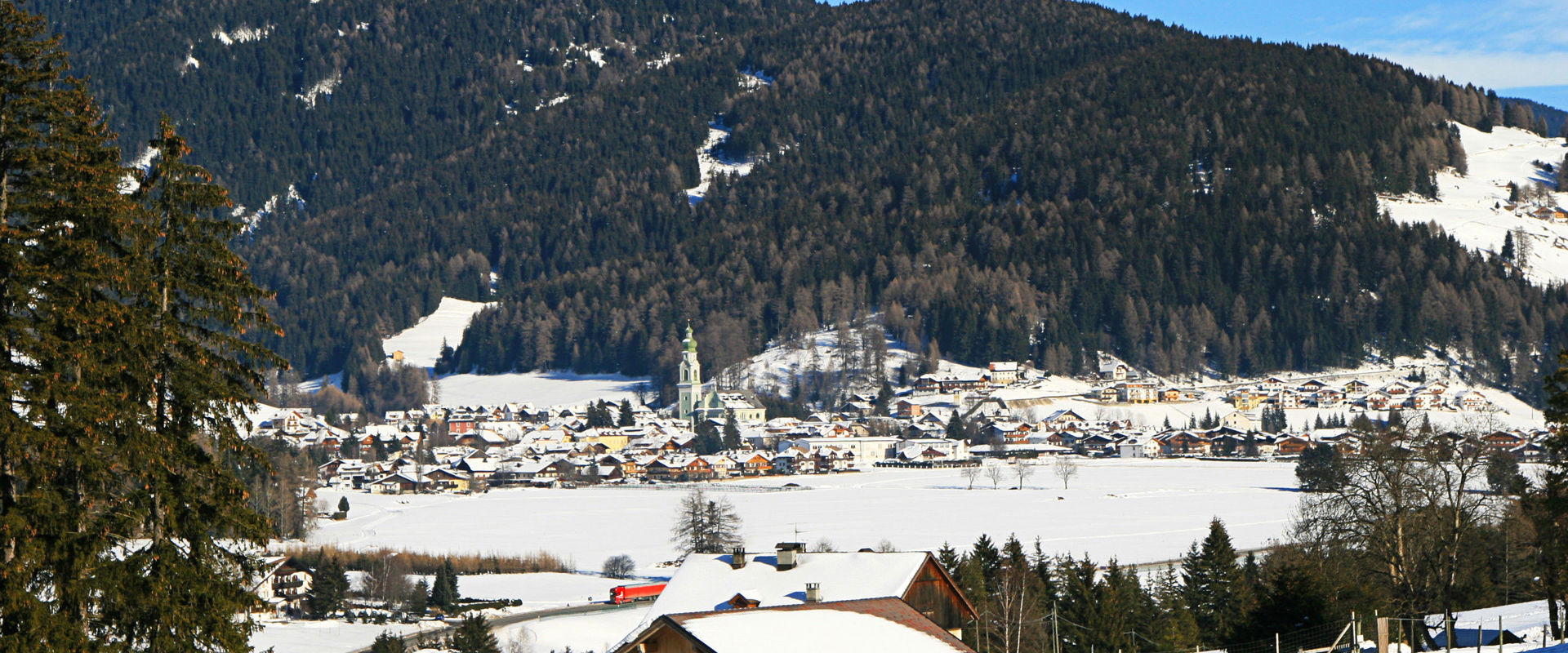 View of Toblach with parish church in winter