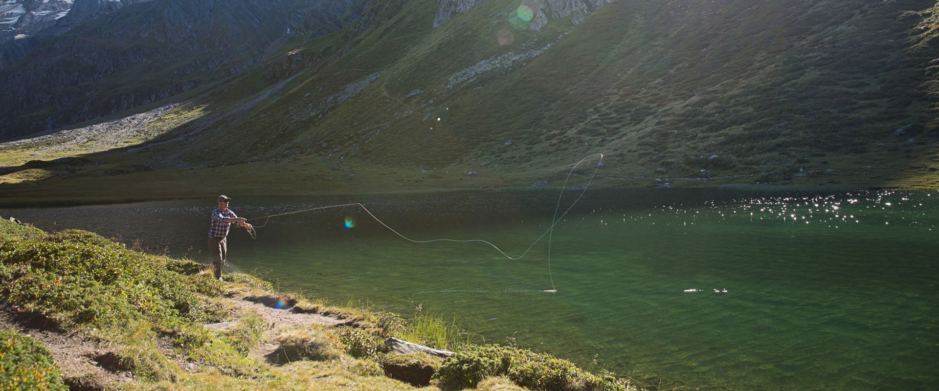 Fishing in the Passeier Valley A man is fishing in a mountain lake in the Passeier Valley.