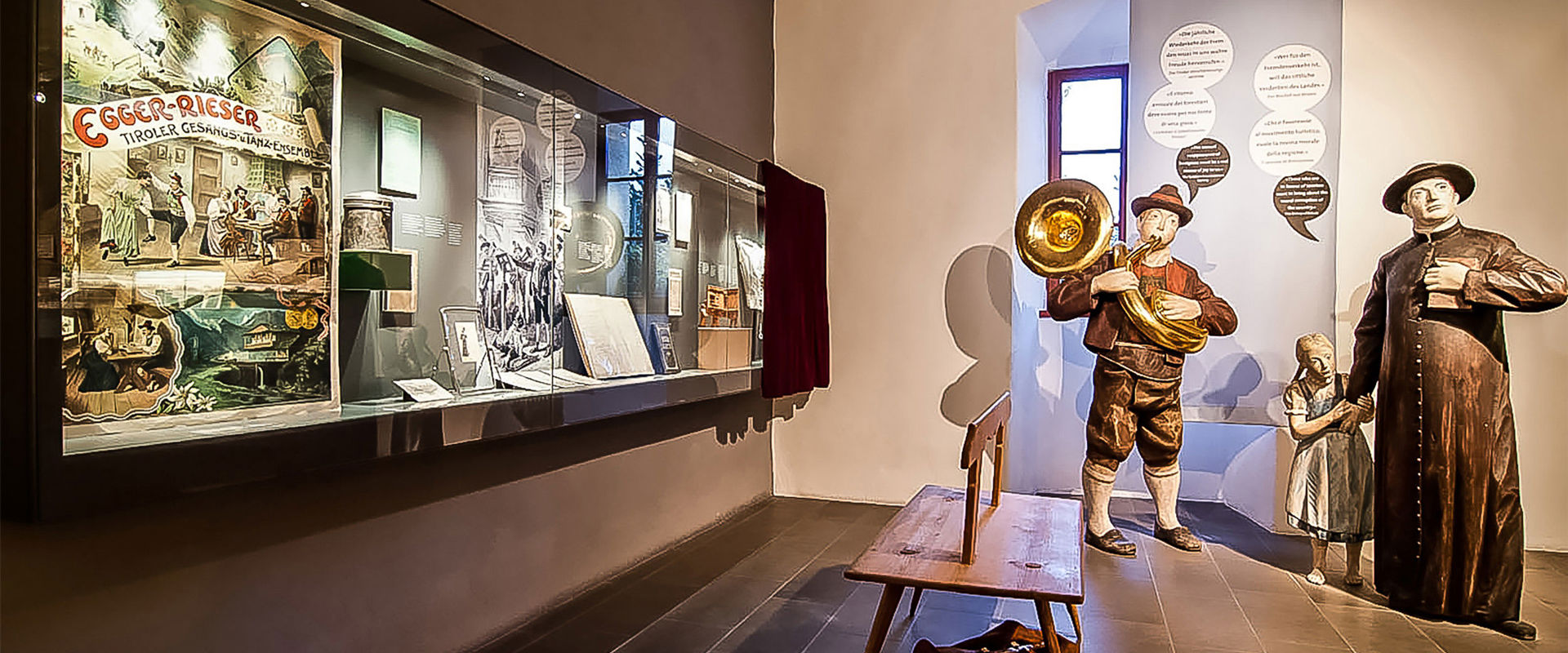 Human-sized wooden figures and a showcase with various rural objects.