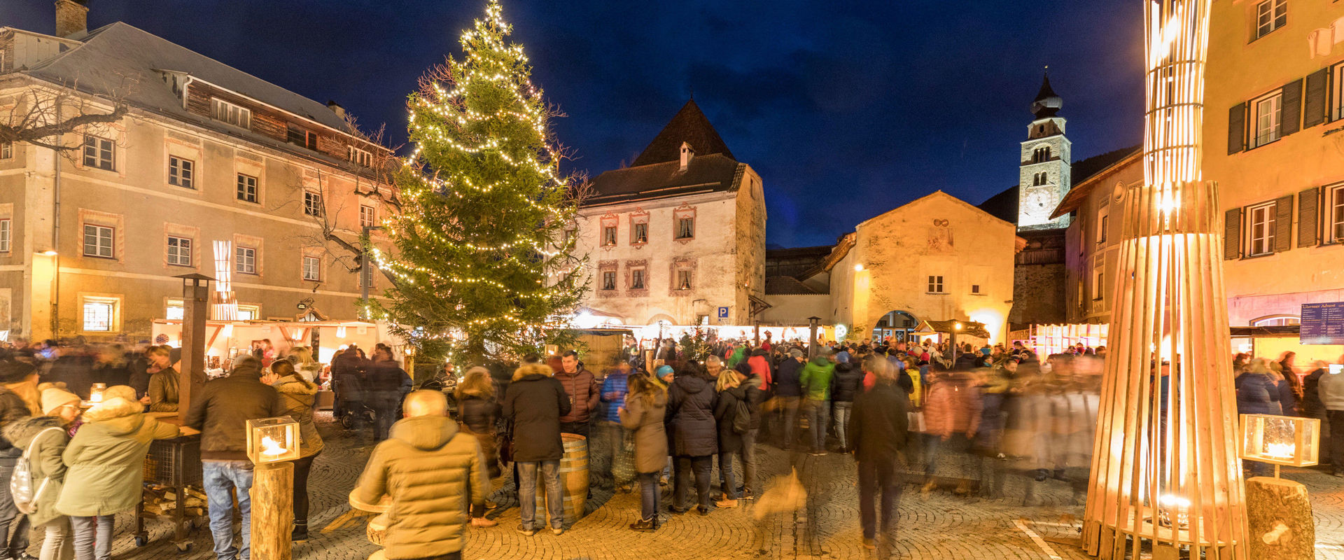 Village square of Glurns in a Christmas atmosphere. Crowded village square in Glurns with Christmas tree and fairy lights.