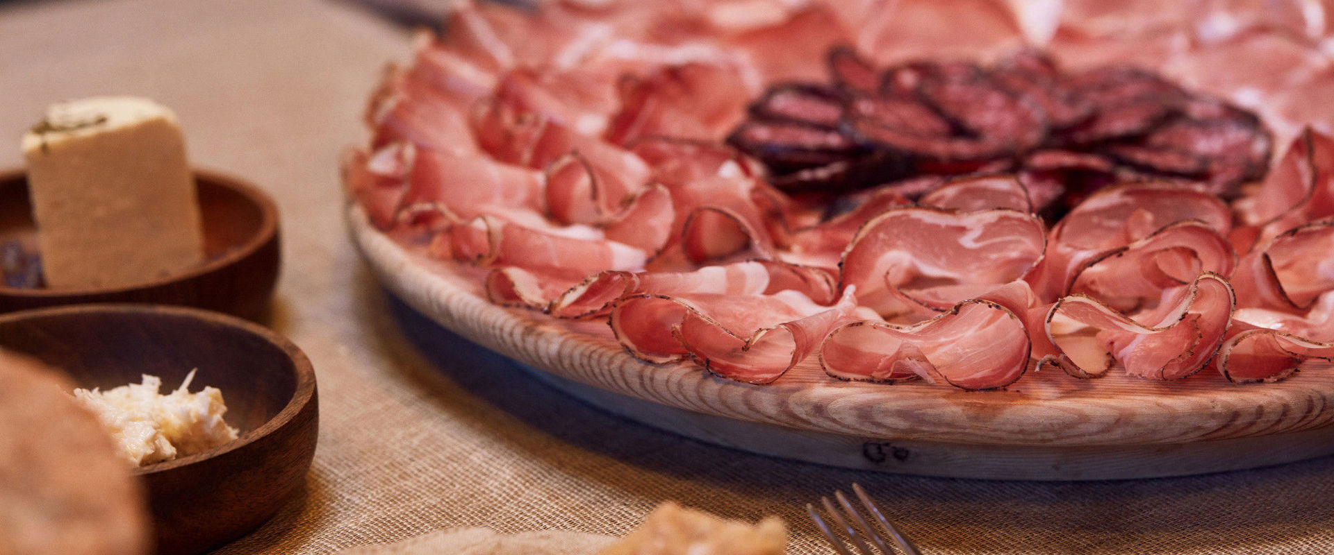 Typical South Tyrolean cold cuts Wooden board with sliced meat.