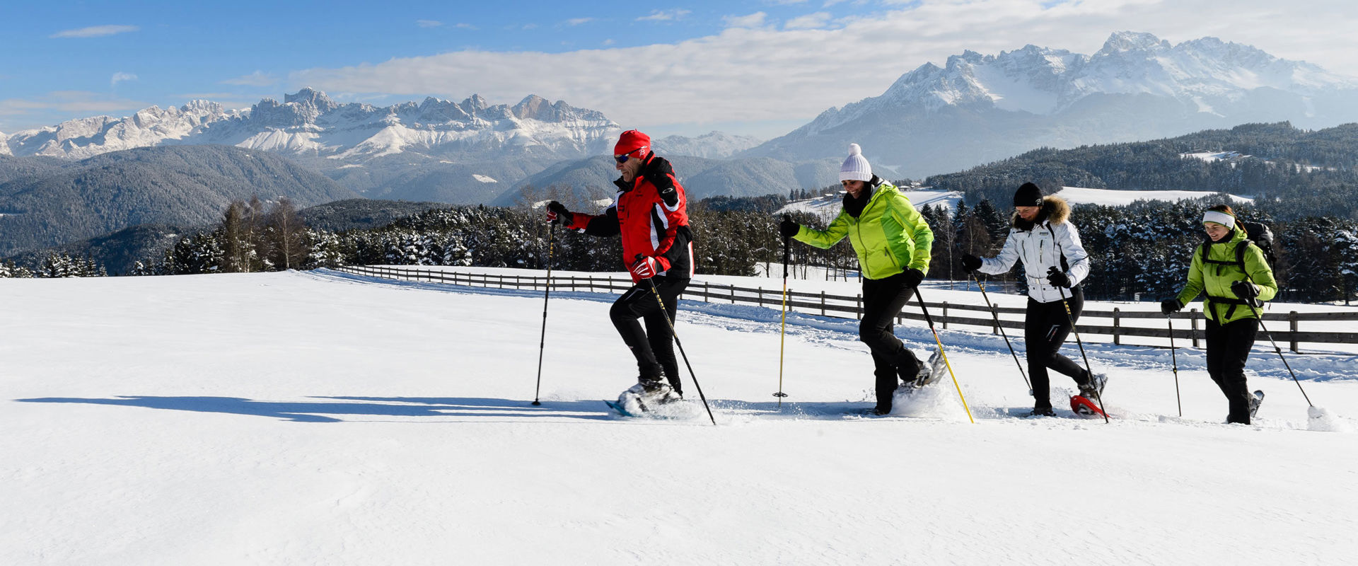 Eggen Snowshoe hikers in new snow with Dolomites scenery