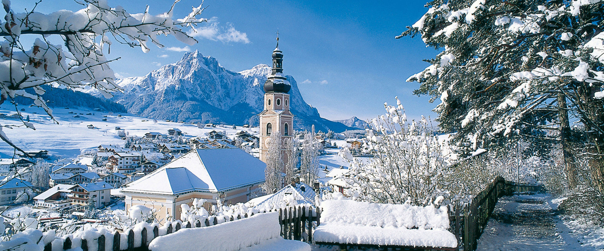 Kastelruth in winter Winter landscape with snow-covered church of Castelrotto.