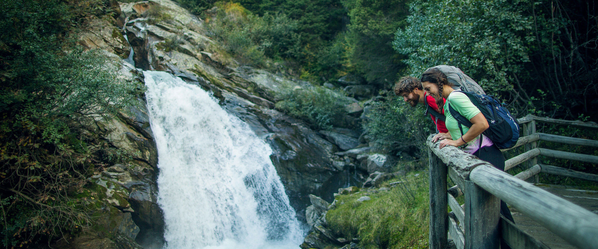 Burkhardklamm Couple looks down into the gorge at the waterfall from a wooden platform.