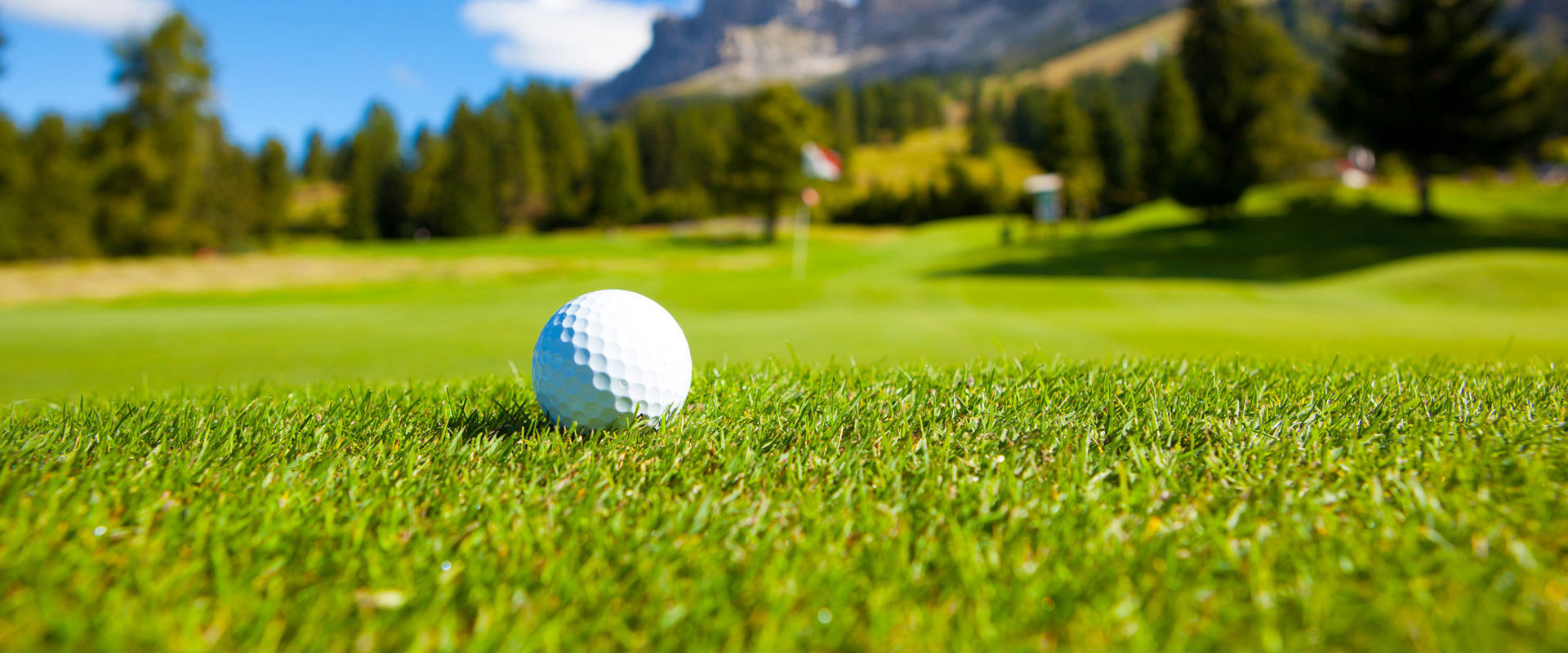 Golf course at the Karersee. A golf ball lies in the meadow on the golf course.