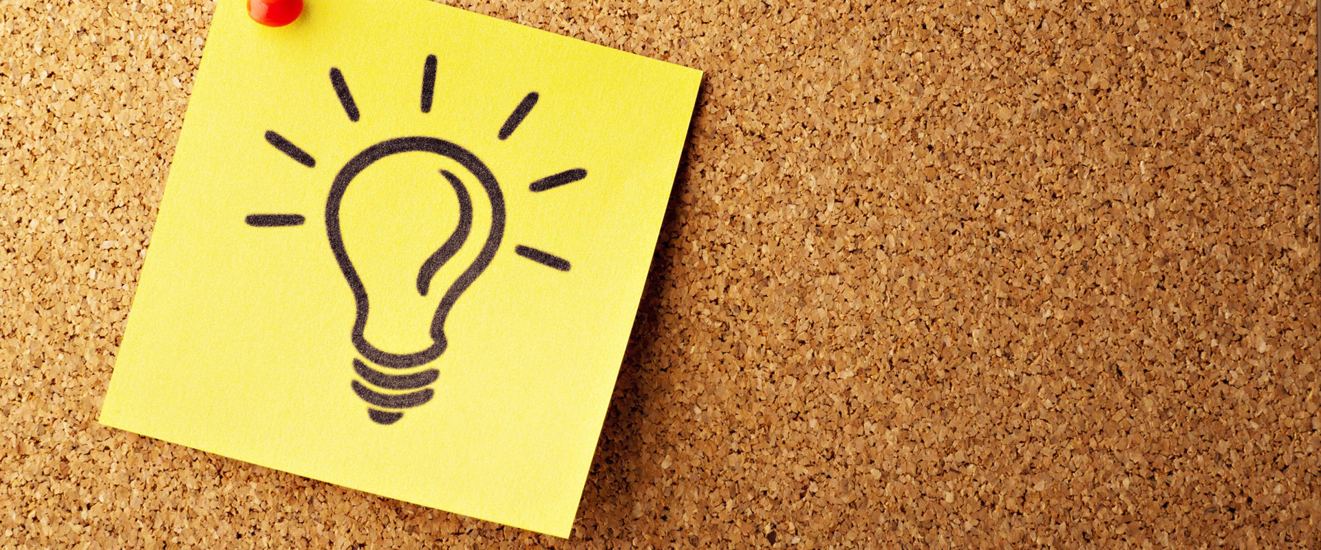 Post-it hangs on a cork wall with your light bulb designed on it.