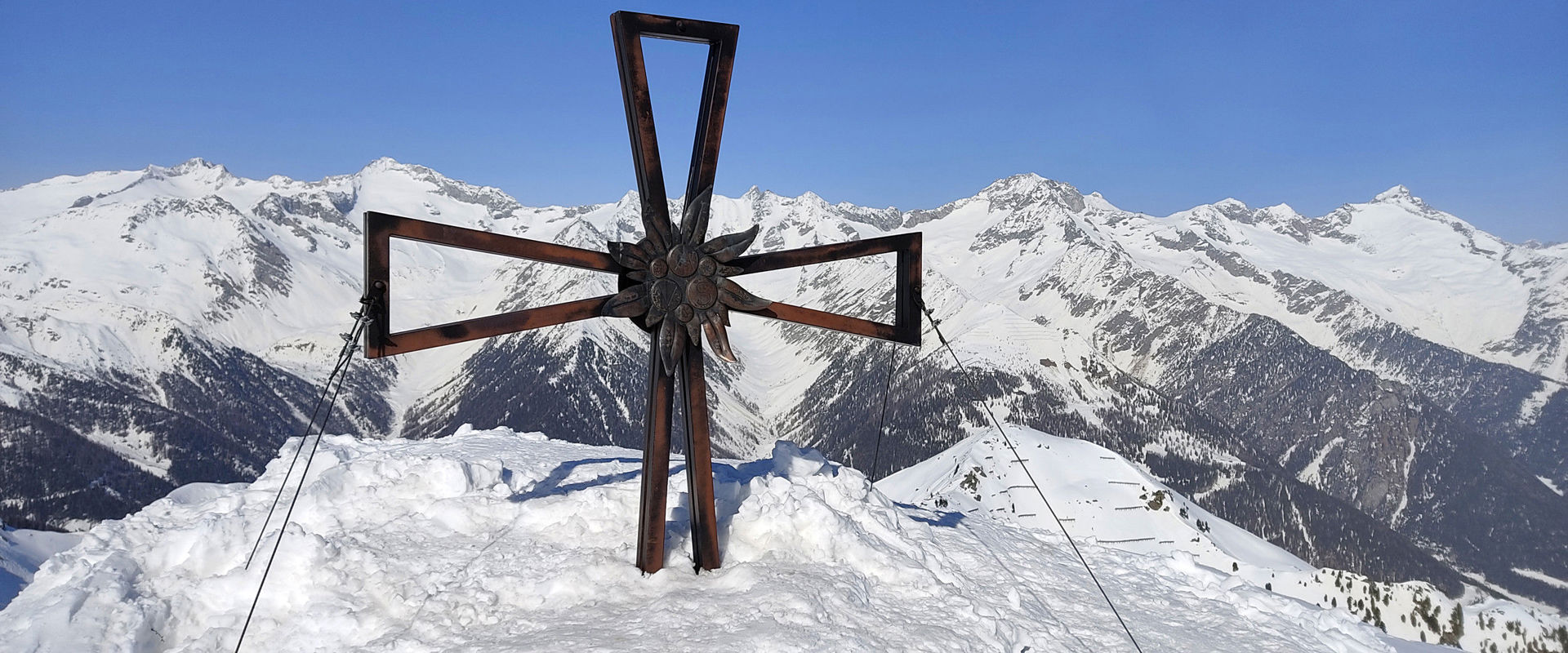 Speikboden summit cross Speikboden summit cross with snow-covered mountain backdrop.
