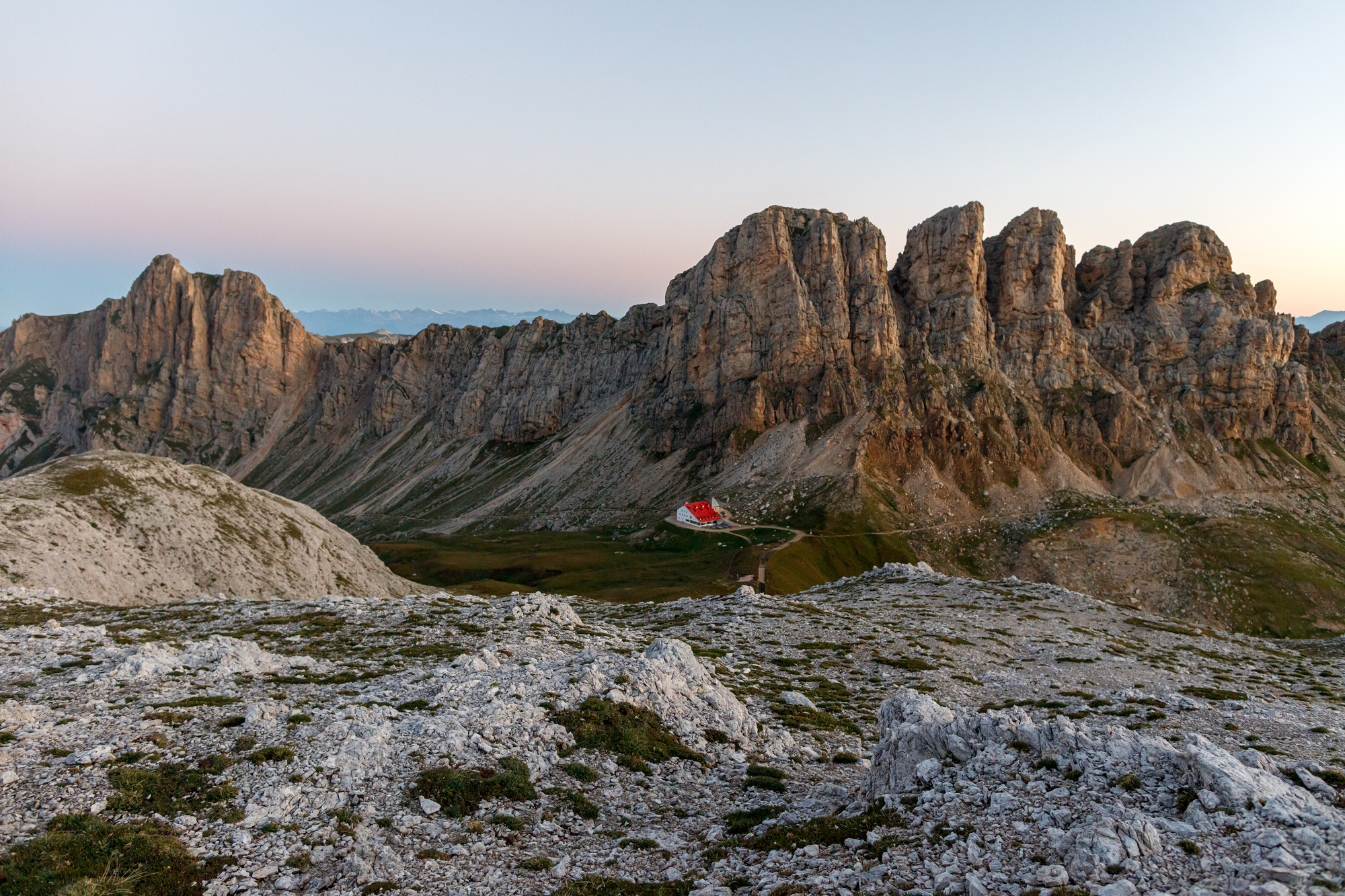 Small mountain hut with red roof in the Dolomite mountains