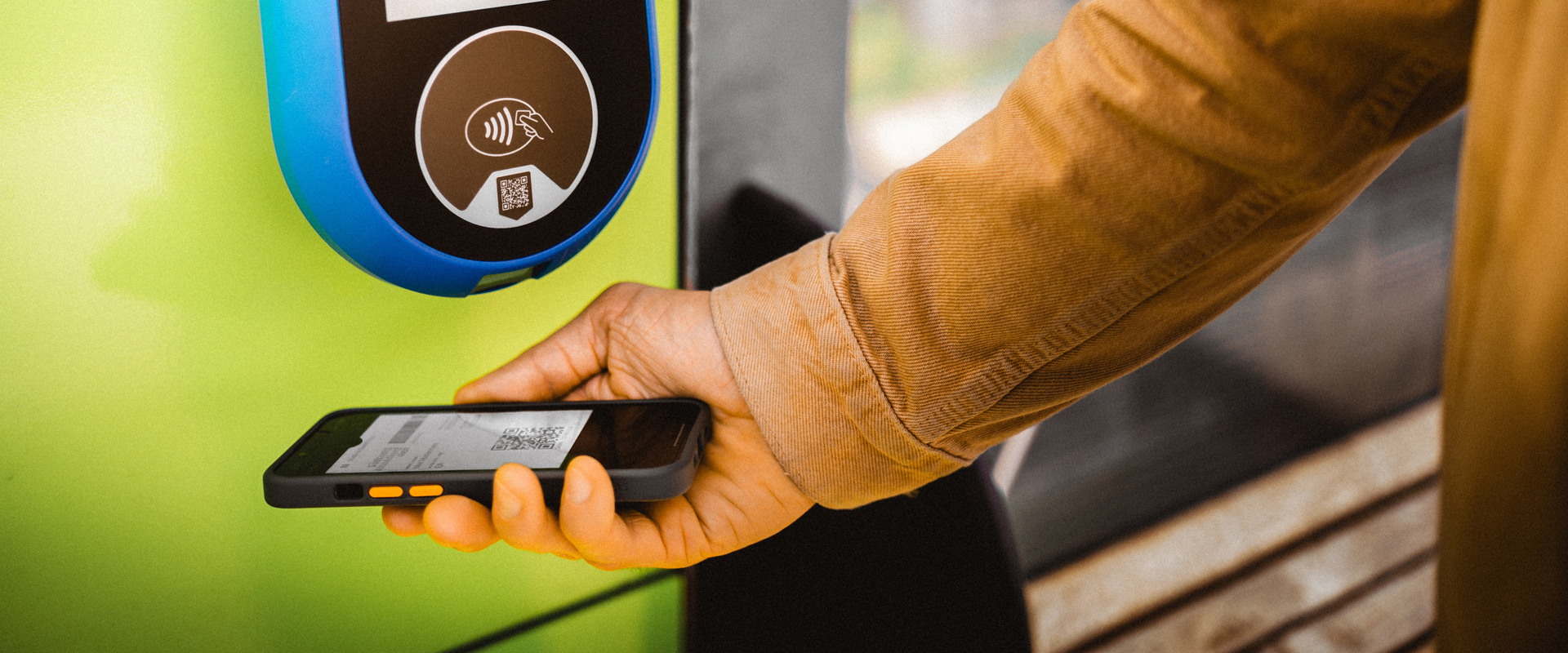 Südtirol Guest Pass Hand holds public transport card on a mobile phone to a device for validation