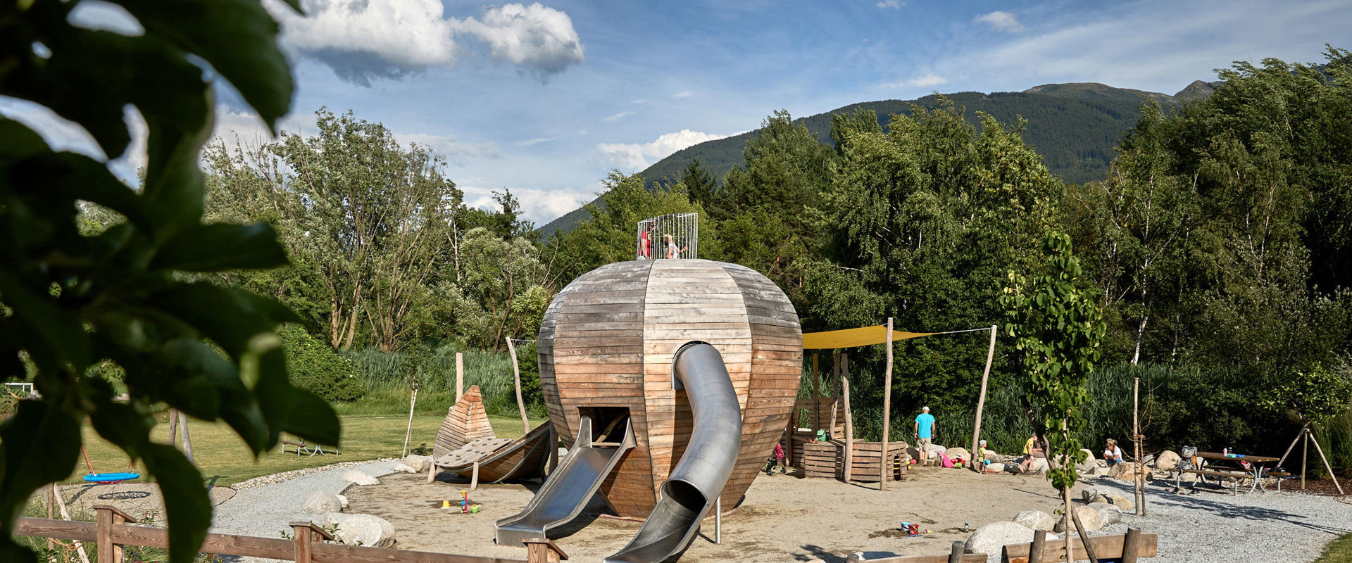 Children's playground "Apfelgarten" in Raas Playground with various games and a slide in the shape of a giant wooden apple.