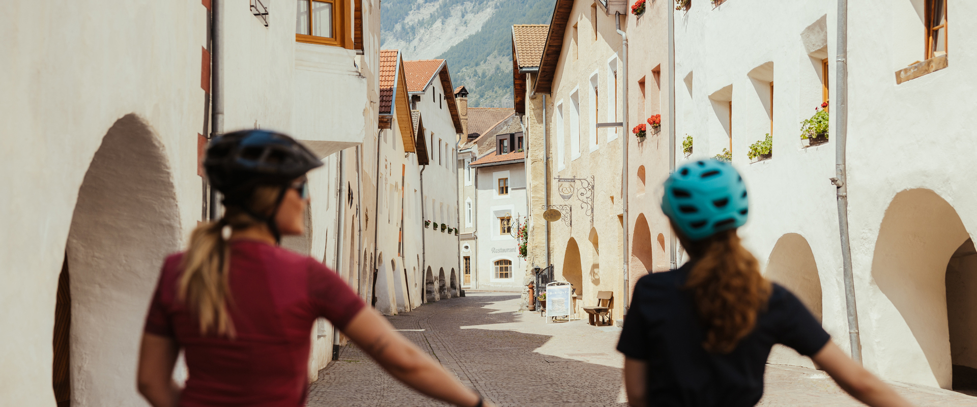 Two cyclists in the historic town centre of Glurns