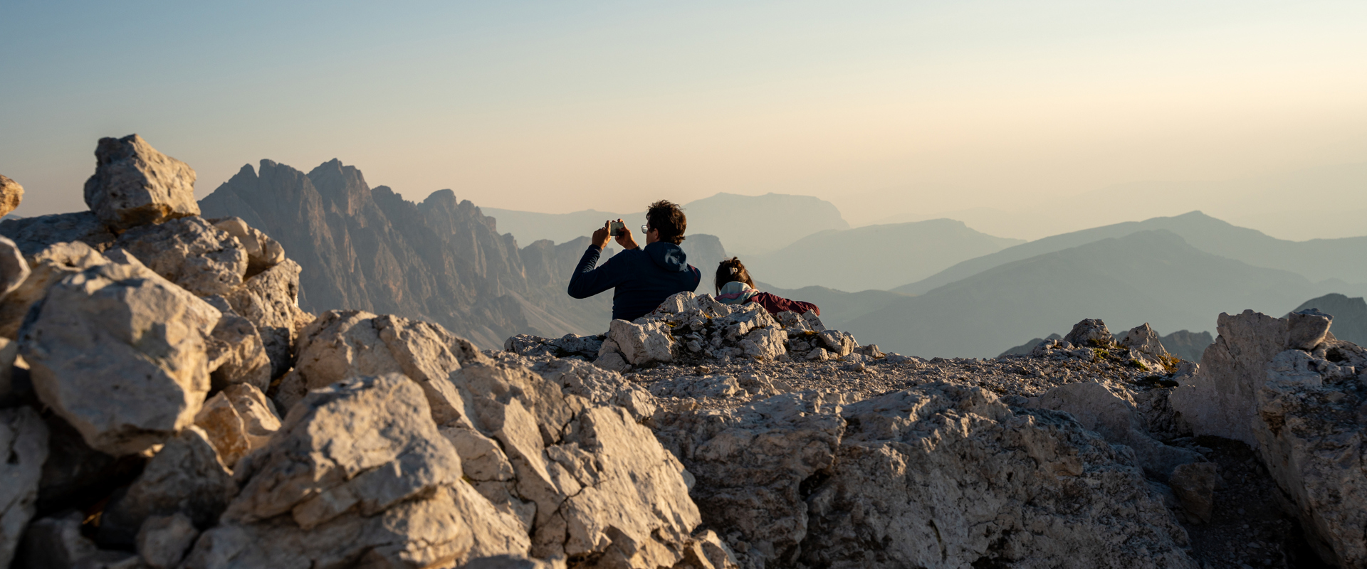 Dolomites panorama Hikers on a mountain peak taking photographs of the view