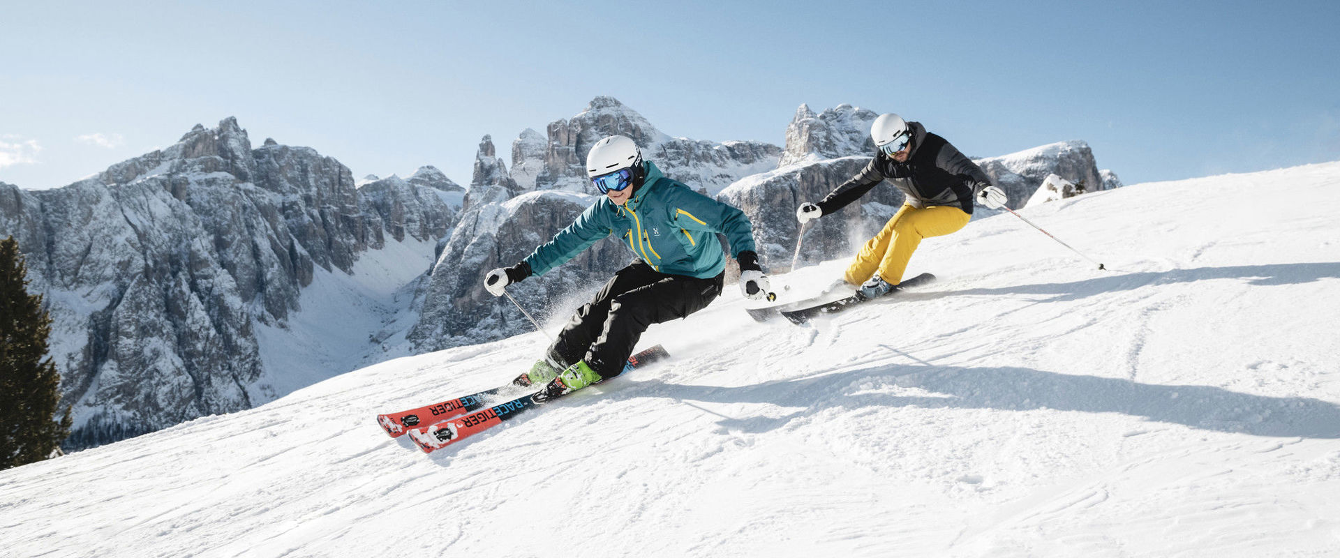 Skier on the ski slope 2 skiers ski down the freshly groomed slope.