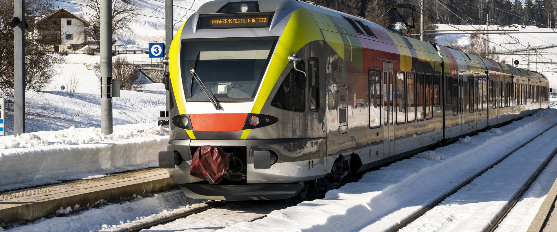 Colourful train standing on a snow-covered railway track