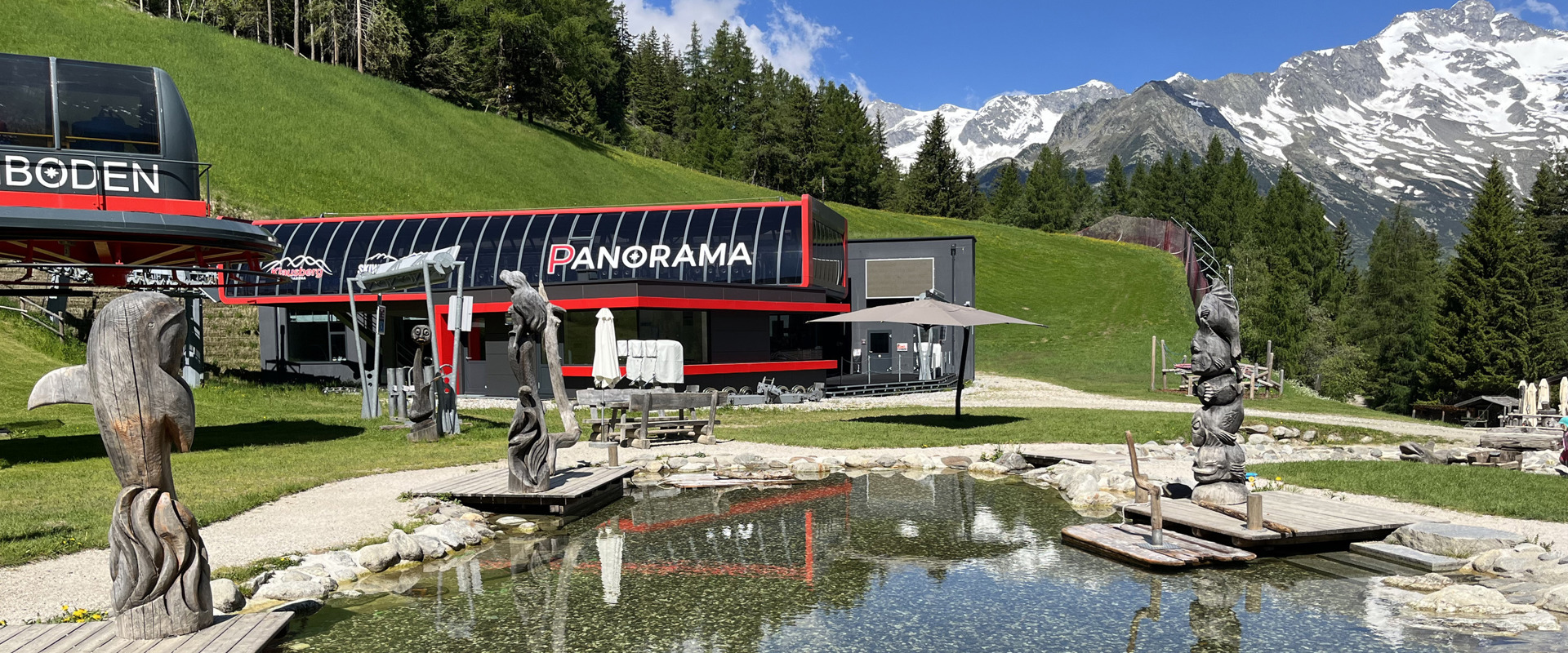 Klausiland Cable car station with pond and carved figures