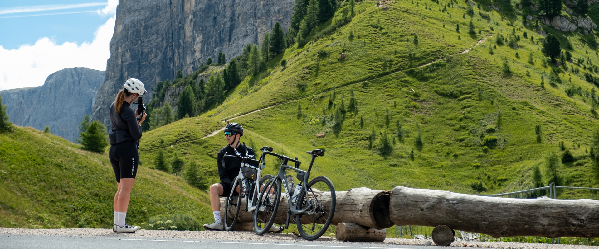 Road biking in the Dolomites Road cyclists taking a break on a mountain pass road in the Dolomites