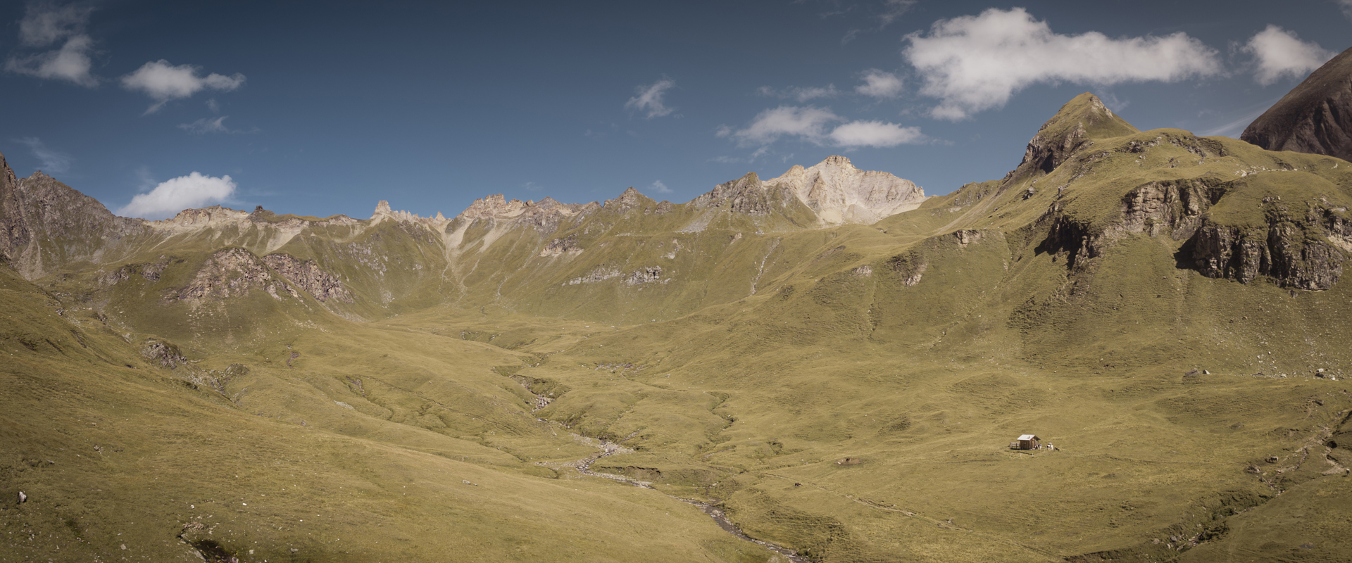 Gentle mountain meadows, huts and mountain peaks 