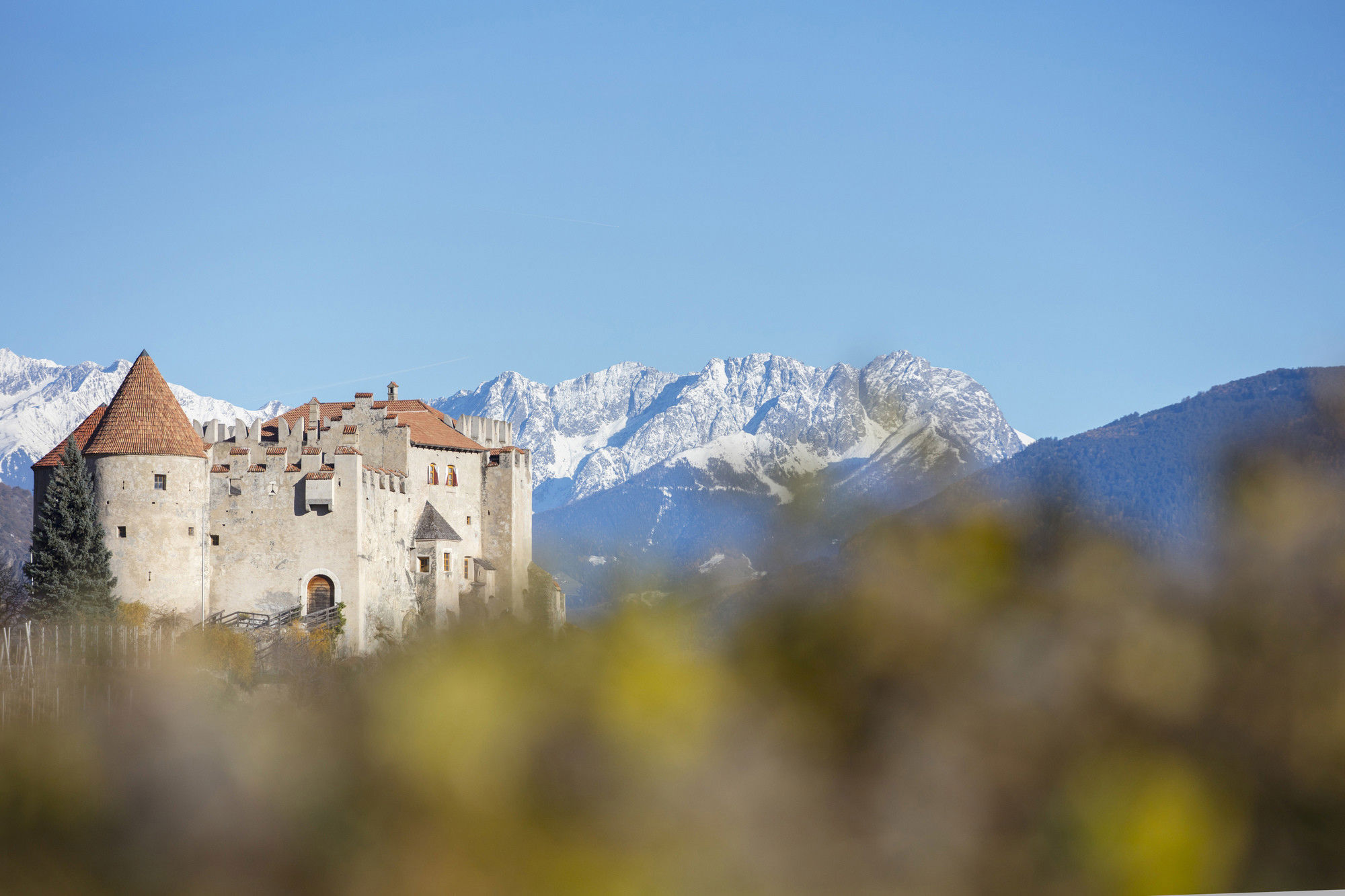 Castle is enthroned in front of the imposing peaks of the snow-covered mountains.